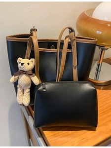 Chic color-block tote bag set with matching pouch and bear charm on wooden desk