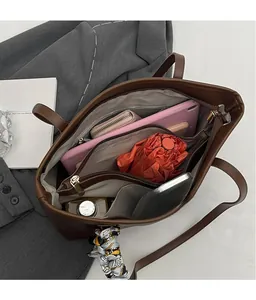 Interior detail of large brown tote bag showing multiple compartments and spacious storage