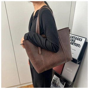 Detail of vintage brown tote bag with matte leather texture for daily commute style