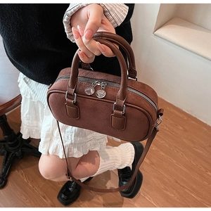 Detail einer braunen Vintage-Zylindertasche mit mattem Wildleder und Ledergriffen