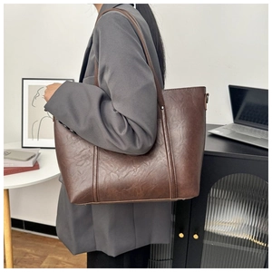 Close-up of a vintage brown tote bag with oily leather texture for office commuting