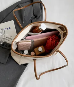 Top-down macro view showing spacious interior and zip pocket of beige tote bag