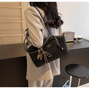 Détail du sac cabas léopard gris avec bandoulière en cuir et pendentif clé dorée élégant