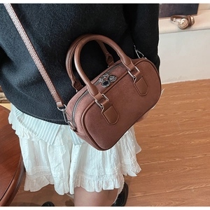 Detailansicht der braunen Boston Bag aus Leder mit feiner Litschi-Narbenstruktur