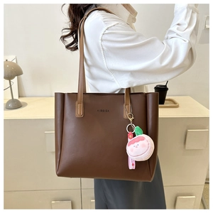 Deep brown tote bag with AIBEIDA logo and pink peach plush pendant shown on model