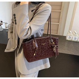 Détail du sac cabas léopard avec pompon tressé et poignée nouée pour femmes élégantes