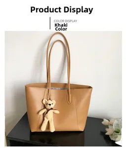 Detail view of khaki faux leather tote bag with zip closure and cute knitted bear charm