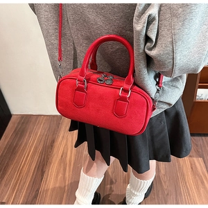 Detail of red boston bag with lychee grain leather texture and metallic zipper charm