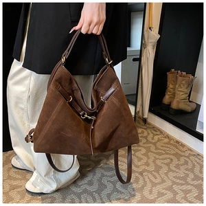 Detail view of large dark brown suede tote bag featuring premium metal hardware and stitching