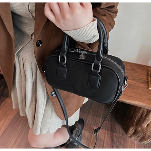 Nahaufnahme der schwarzen Boston Bag mit Lychee-Maserung, Silberbeschlägen und Styling