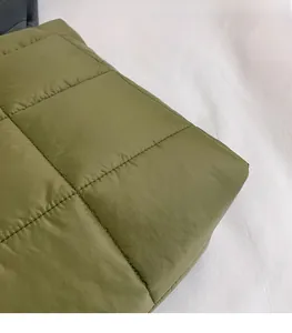 Detailansicht aus olivgrünem gestepptem Stoff mit feinen Nähten für eine Handtasche