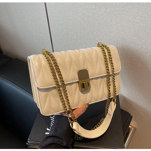 Detail of cream quilted shoulder bag with vintage gold twist lock and chain strap