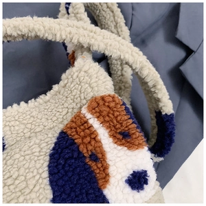 Close-up of curly plush fabric texture and cartoon dog pattern on a soft shoulder bag