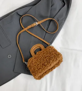Close-up of brown wool shoulder bag featuring a round handle and adjustable strap