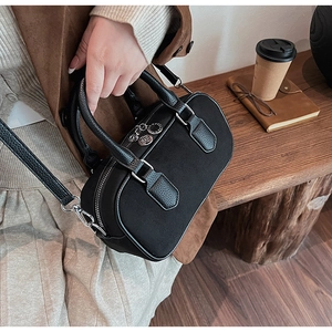 Details einer schwarzen Boston-Tasche aus Wildleder mit silbernen Metallanhängern