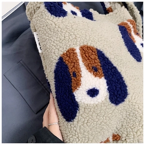 Close-up of plush bucket bag featuring soft faux shearling and cartoon dog patch detail