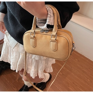 Detail der senfgelben Boston Bag mit Wildlederstruktur und litchi-geprägtem Lederfinish