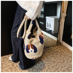 Detail of soft fleece bucket bag with blue and brown dog patchwork and wide strap
