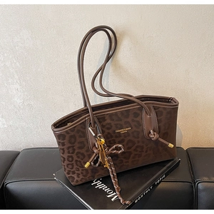 Détail du sac cabas léopard avec texture velours marron et porte-clés tressé élégant
