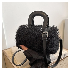 Close-up of black fuzzy lamb wool crossbody bag with leather handles and silver hardware