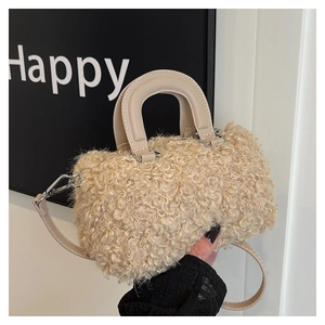 Close-up of soft beige faux fur handbag featuring structured handles and fuzzy texture