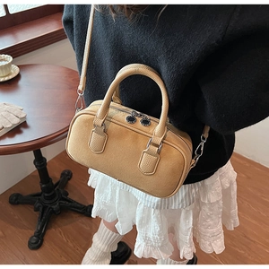 Detail der gelben Boston-Tasche aus Lychee-Leder mit Doppelreißverschluss und Trageriemen