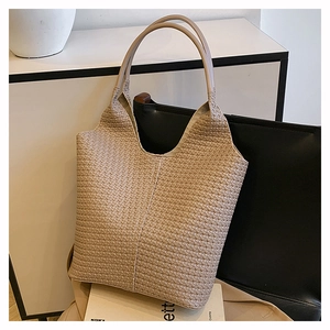 Gros plan détaillé sur la texture en cuir synthétique tressé de ce sac cabas