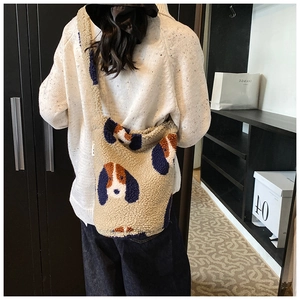 Detail of plush shoulder bag featuring a cute cartoon dog pattern on apricot lamb fleece