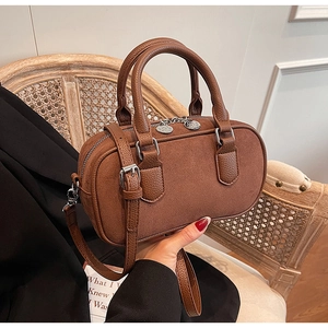 Nahaufnahme der braunen Zylindertasche mit Vintage-Matt-Textur und Silberbeschlägen