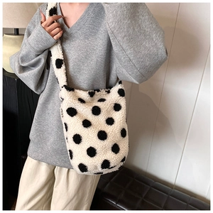 Close-up of fluffy faux fur bucket bag with black polka dots and MISS label detail