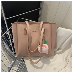 Detail of nude pink leather tote bag with brand logo inside a metal shopping cart