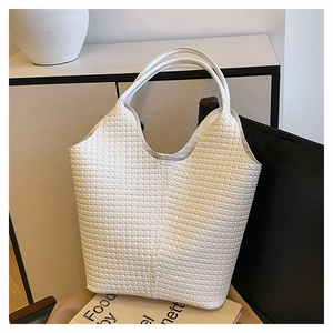 Vue détaillée du sac cabas tressé blanc avec texture en damier sur fond minimaliste