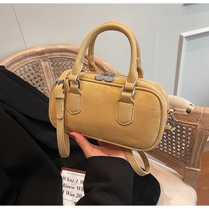 Detail der senfgelben Tasche aus Wildleder und Leder mit Doppelreißverschluss