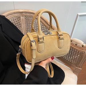 Detail der gelben Boston Bag mit Wildlederstruktur und Griffen aus Litschi-Leder