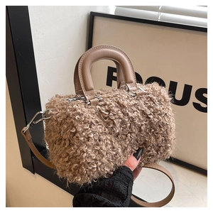 Detail of plush lambskin textured mini bag with smooth handle and leather crossbody strap