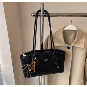 Détail du sac cabas léopard avec lettrage doré et pendentif en forme de clé en métal