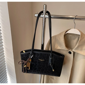 Détail du sac cabas à imprimé léopard avec texture peluche et lettrage doré de marque