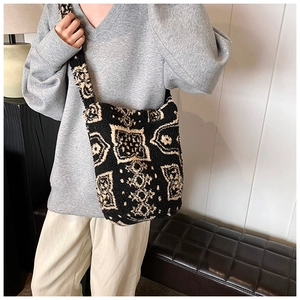 Detail of plush crossbody bucket bag featuring vintage geometric patterns and soft texture