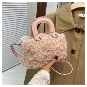 Detailed close-up of pink faux shearling texture and silver hardware on a crossbody bag
