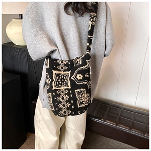 Furry bucket bag featuring black and white geometric patterns on a person's shoulder