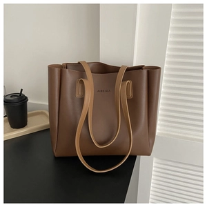 Detail of AIBEIDA embossed logo on a deep coffee large tote bag with textured leather