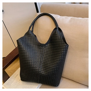 Gros plan détaillé sur la texture en cuir tressé noir d'un sac cabas élégant et chic