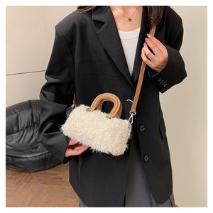 Detail of a mini plush crossbody bag featuring beige wool fabric and brown leather straps