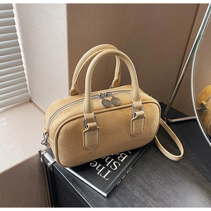 Detailansicht der gelben Boston Bag aus Wildleder und genarbtem Leder mit Goldbeschlägen