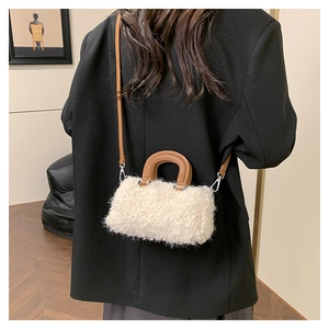 Close-up of fluffy white faux fur texture and brown leather strap on the mini handbag