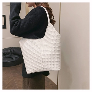 Détail du sac cabas tissé blanc avec large bandoulière sur mannequin en tenue décontractée