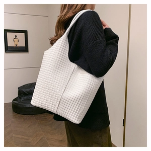 Gros plan du sac cabas blanc texturé montrant le tissage géométrique et la grande taille