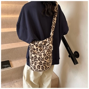Detailed view of leopard print plush tote bag showing soft faux fur texture and wide strap