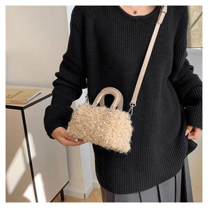 Detail of plush wool crossbody bag featuring a round top handle and silver hardware