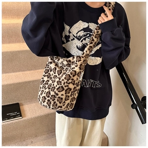 Detailed shot of a fluffy leopard print bucket bag with a MISS label on soft faux fur
